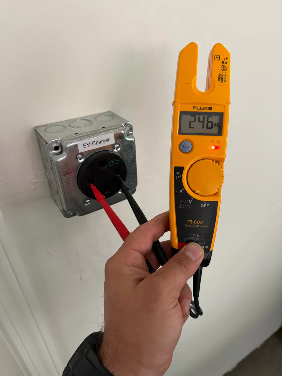 Testing a new NEMA 14-50 outlet in a surface-mount box at 246V